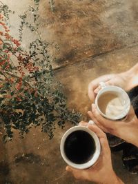 Directly above shot of hand holding coffee cup