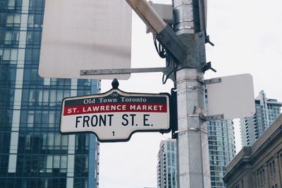 Low angle view of road sign against buildings in city