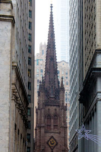 Low angle view of trinity church amidst buildings