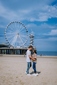 Low angle view of man with ferris wheel against sky