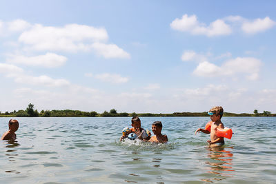 People enjoying in water against sky