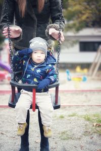 Baby boy playing in park with mother