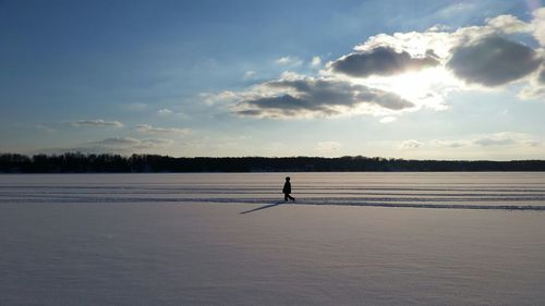 Person walking on snow covered landscape