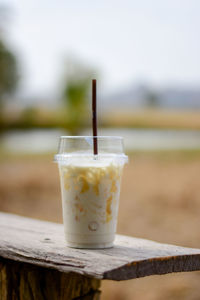 Cold caramel milk in clear plastic glasses on glass table