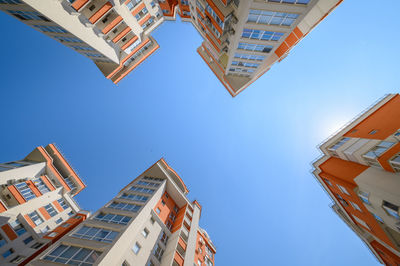 Low angle view of buildings against clear blue sky