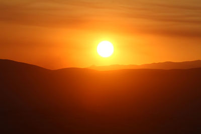 Scenic view of silhouette mountains against romantic sky at sunset