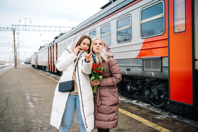 Girls at the train station waiting to meet pointing the direction