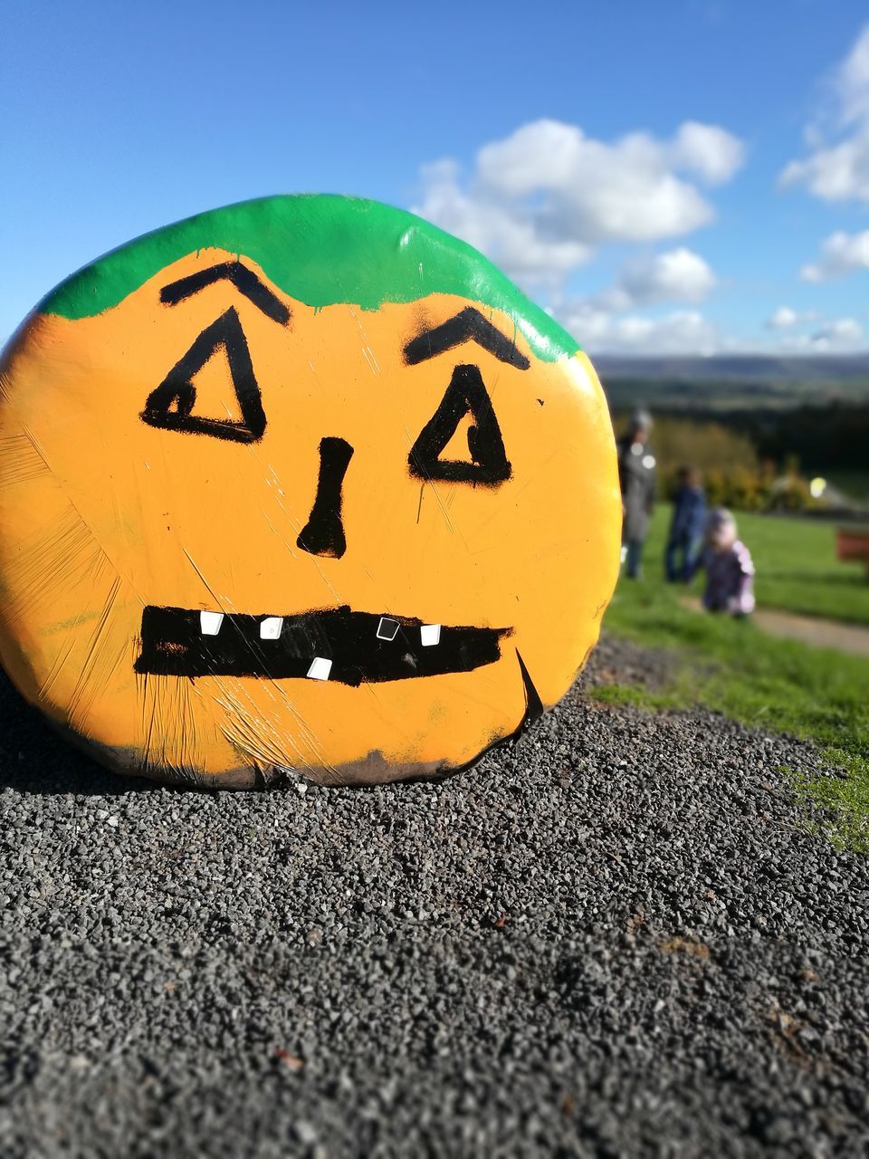 CLOSE-UP OF YELLOW PUMPKIN ON ROAD AGAINST SKY