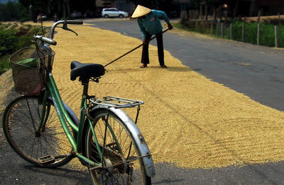 Worker spreading rice for drying