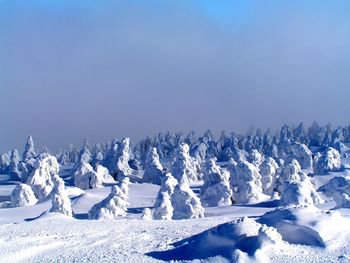 Panoramic view of snow landscape against clear blue sky