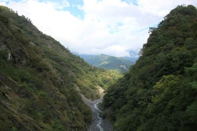 Scenic view of mountains against cloudy sky