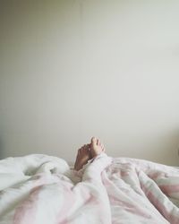 Low section of man sleeping on bed