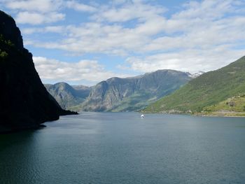 Scenic view of sea and mountains against sky