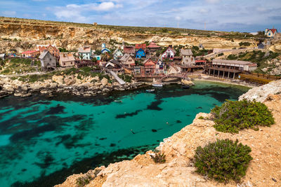 High angle view of buildings by sea against sky