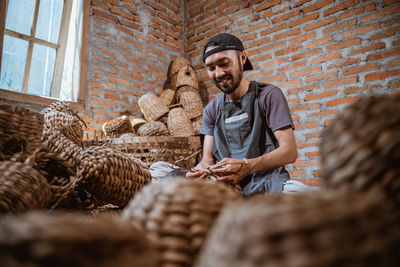 Portrait of young man sitting on wicker basket