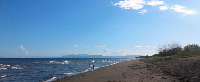 Scenic view of beach against cloudy sky