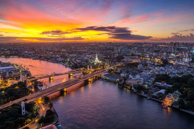 High angle view of illuminated city during sunset