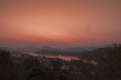 Scenic view of silhouette mountains against orange sky