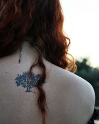 Rear view of young woman with tree tattoo