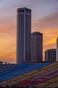 Modern buildings in city against sky during sunset