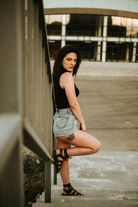 Fashionable young woman standing on steps in city