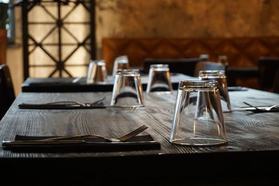 Empty glasses with forks arranged on table in restaurant
