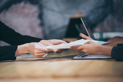 Cropped hands of businesswoman interviewing female candidate in office