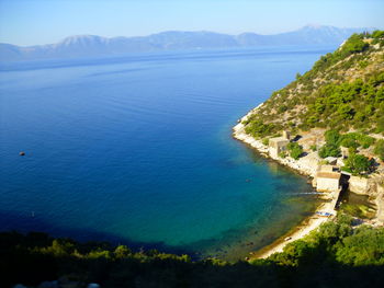 Scenic view of sea and mountains against sky