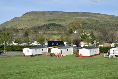 Houses on field against sky