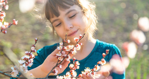 Close-up of girl looking at flowers