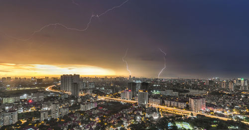 Aerial view of illuminated city against sky at night