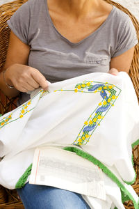 Midsection of woman embroidering on fabric