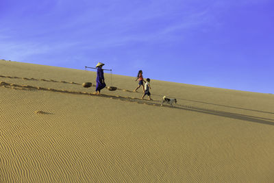 People riding on landscape against sky