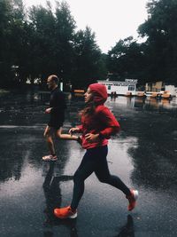 People on wet street in city during rainy season