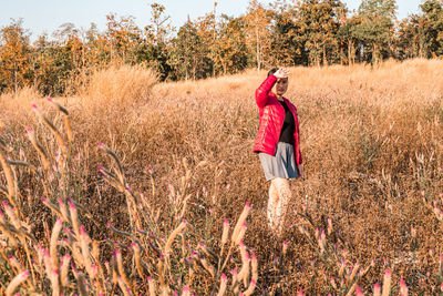 Full length of woman standing on field against sky