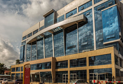 View of office building against cloudy sky