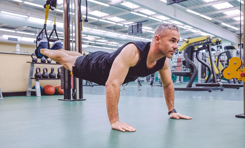 Full length of man exercising at gym