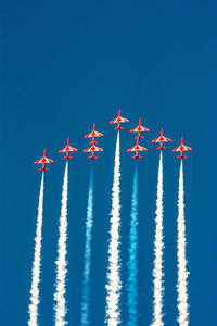 Low angle view of airplane flying against clear blue sky