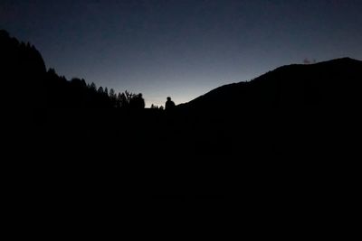 Low angle view of silhouette mountain against clear sky at dusk