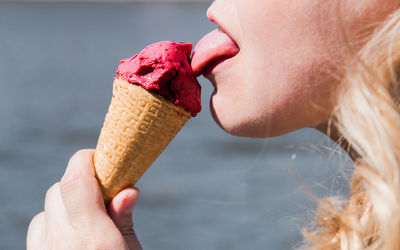Midsection of woman licking ice cream cone