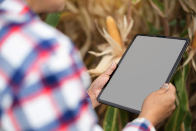 Midsection of woman using digital tablet