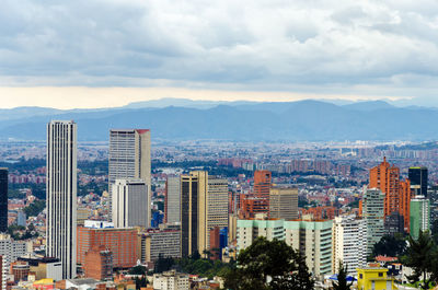 View of cityscape against cloudy sky