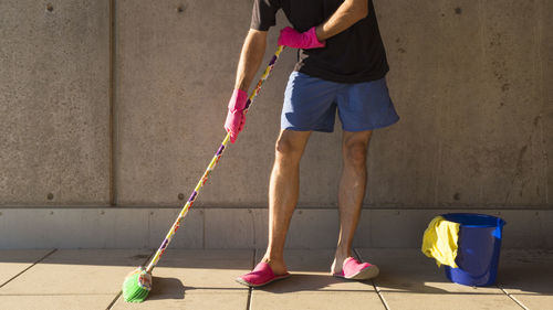 Low section of man cleaning footpath