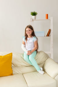 Portrait of smiling woman sitting on sofa at home