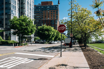 Road sign by buildings in city