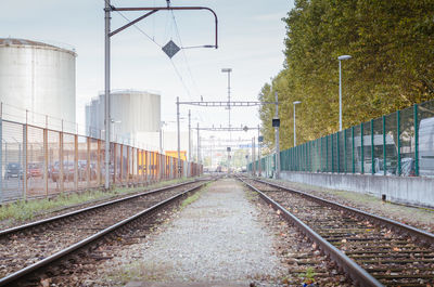 Railroad tracks amidst trees against sky