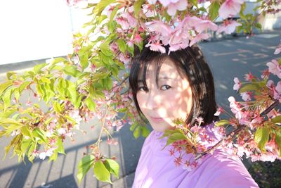 Portrait of woman against pink flowering plants