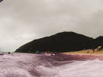 People on beach against sky