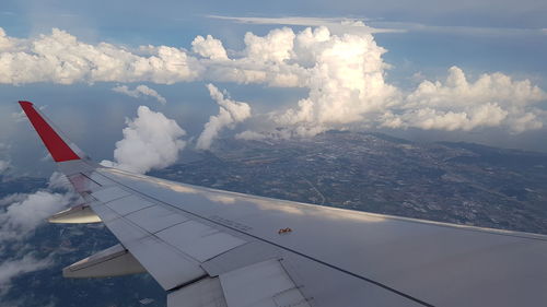 Aerial view of aircraft wing against sky