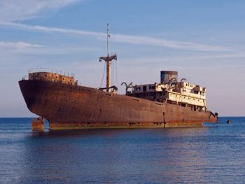 Abandoned ship on sea against sky